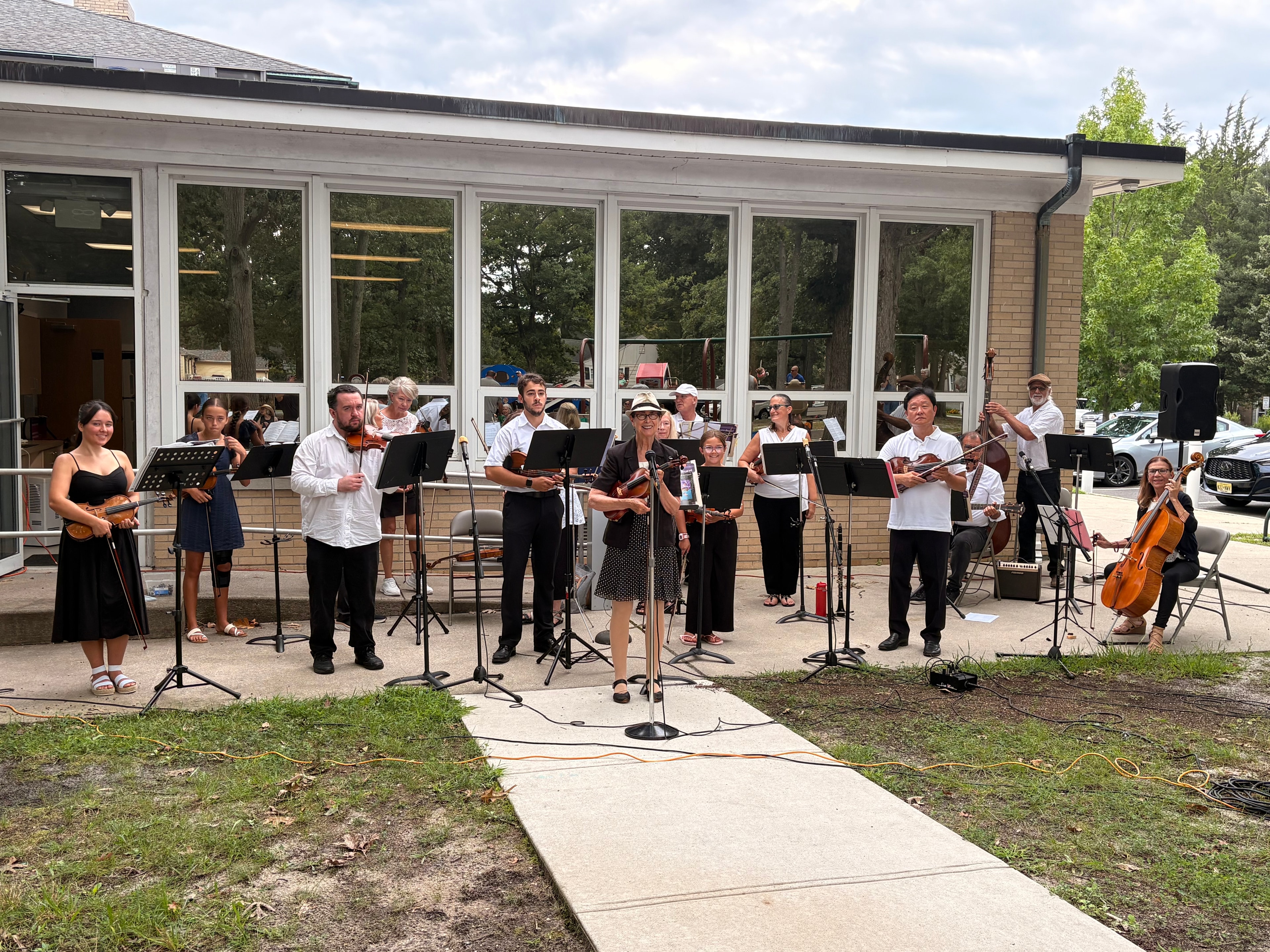 Fiddle Club performing outdoors at a community library event