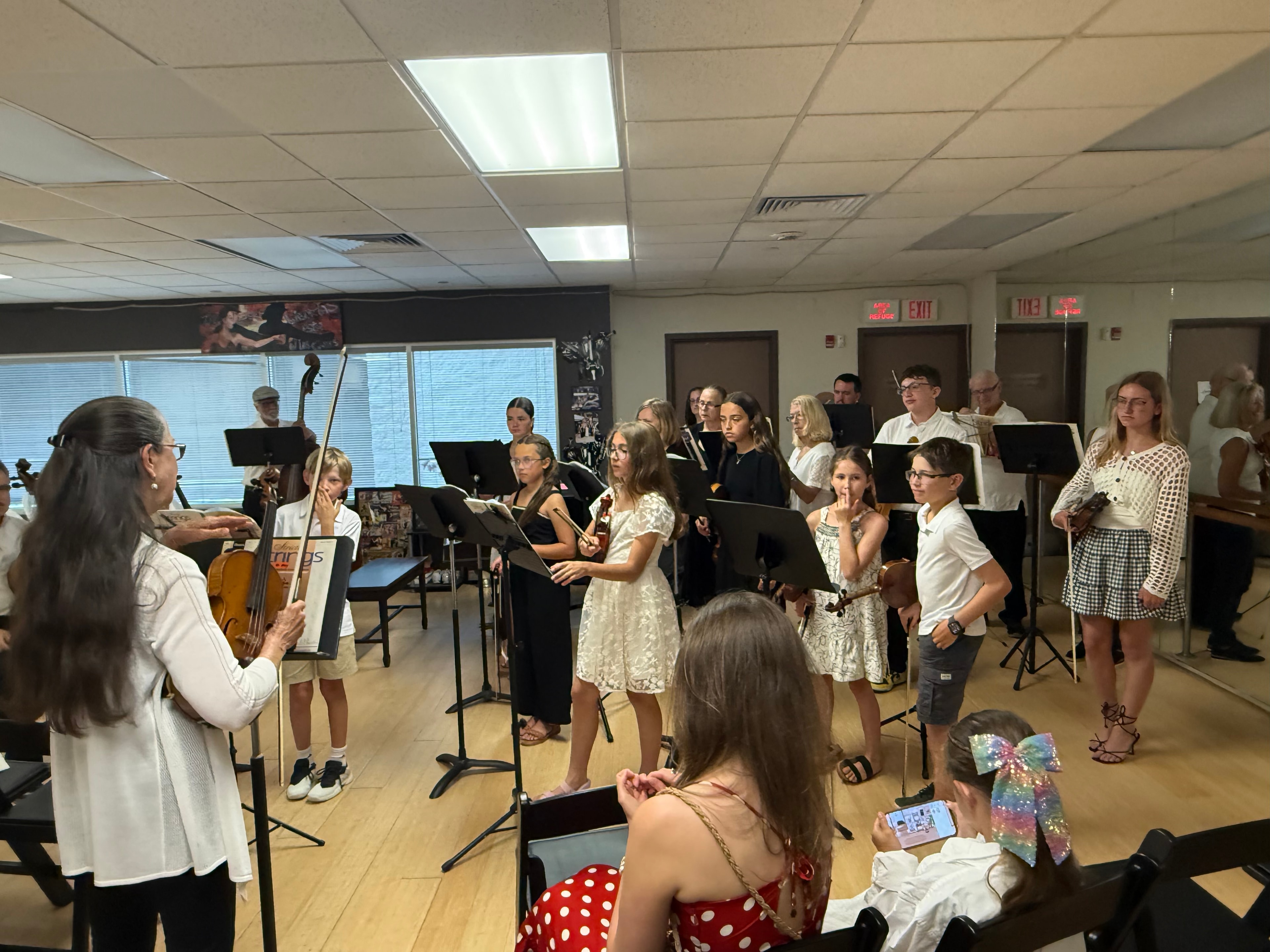 Dr. May Strange conducting students at the Spring String Student Recital