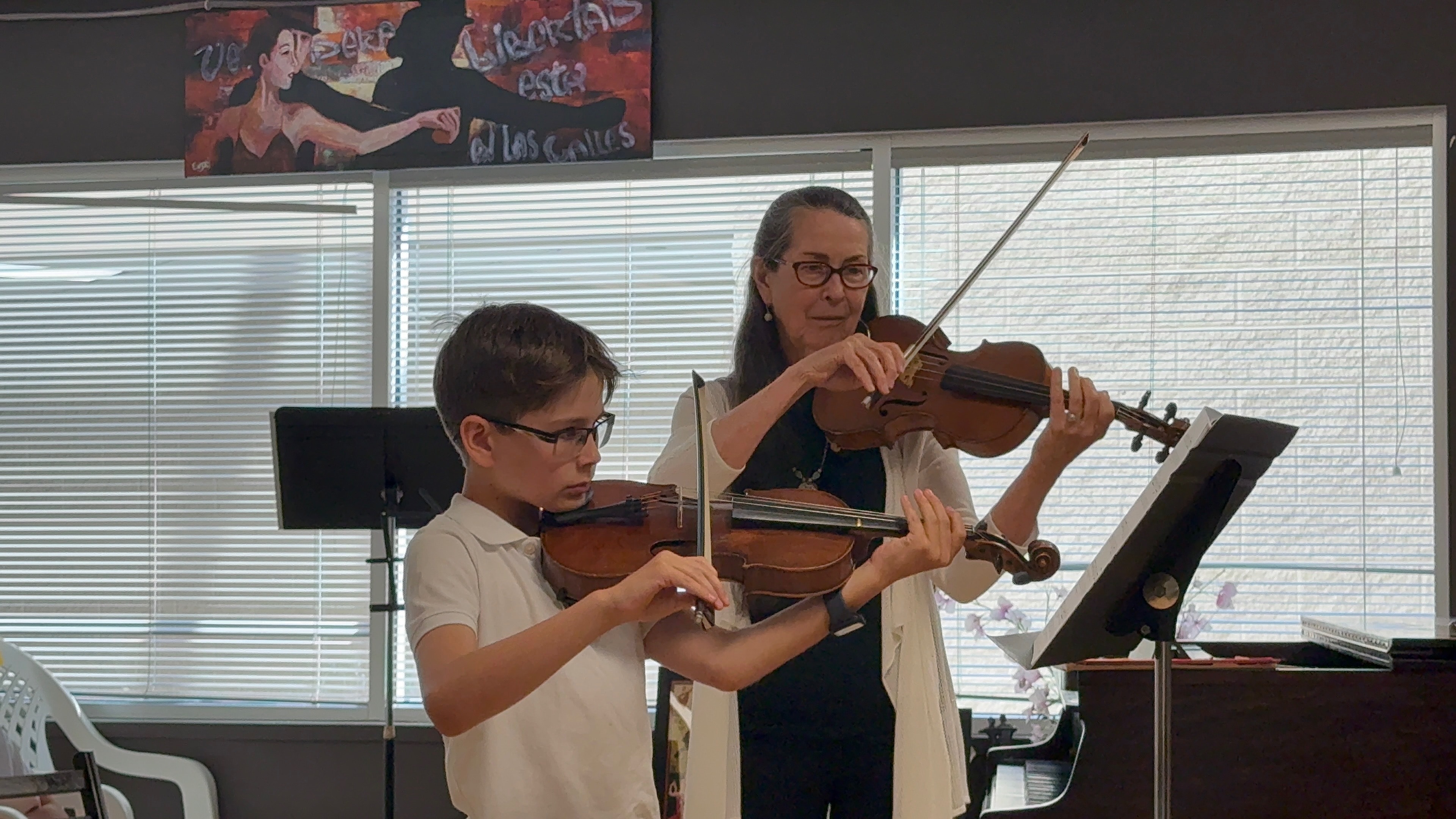 Student practicing violin with instructor